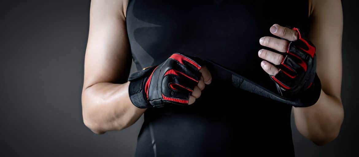 Les mains d'un sportif portant des gants de musculation