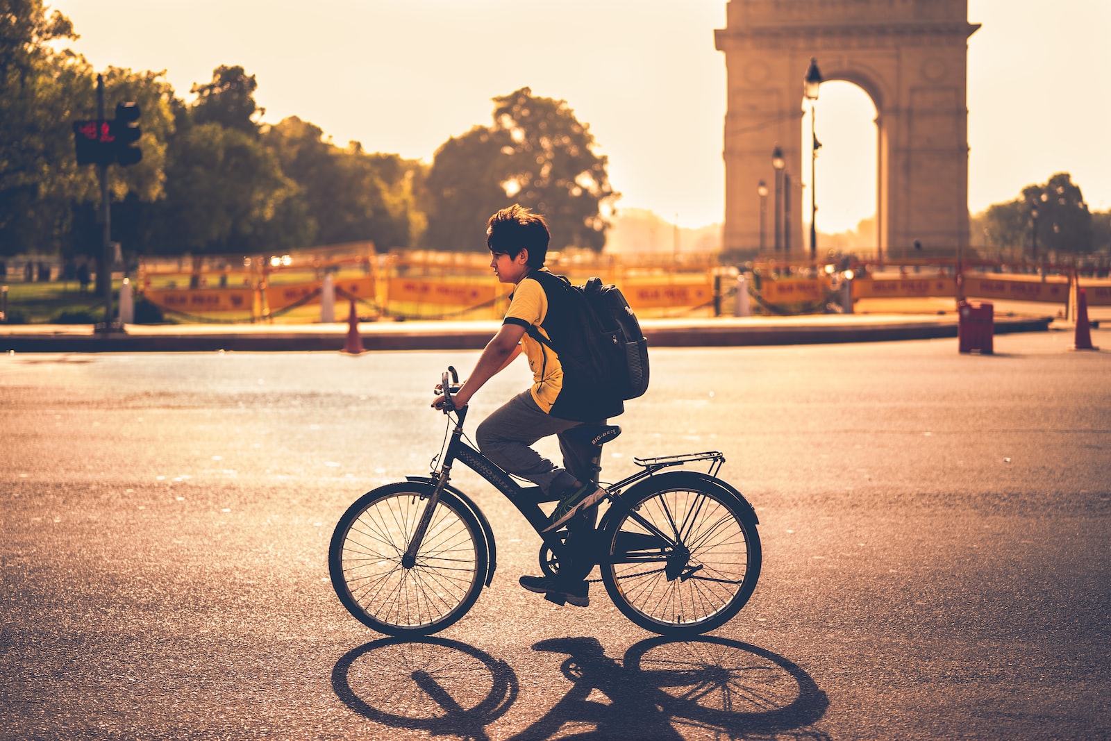 boy riding bicycle beside India gate