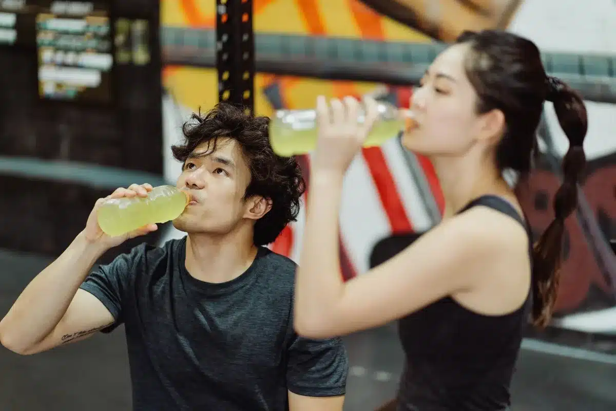 Différentes boissons de sport et bouteilles d'eau sur une table d'entraînement