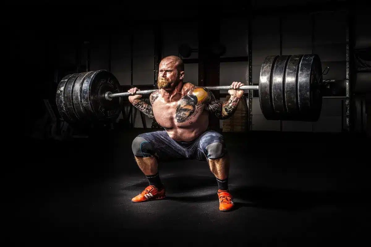 Haltérophile soulevant une barre lourde en salle de musculation