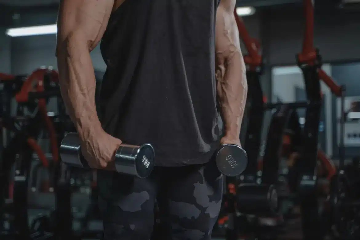 Athlète musclé observant sa silhouette maigre dans un miroir de salle de musculation