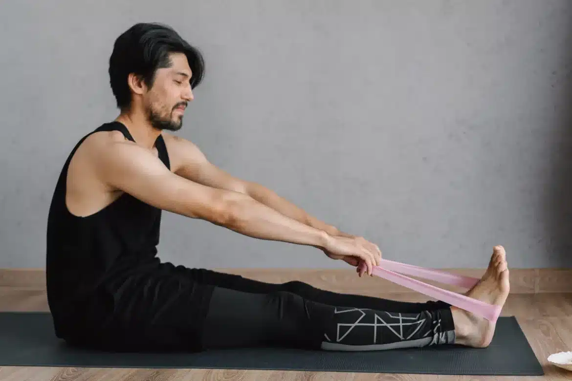 Personne se massant l'épaule après l'entraînement pour soulager les courbatures musculaires.