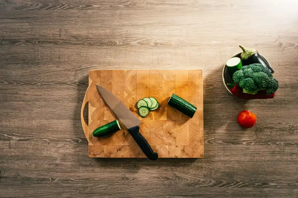 Courgettes fraîches tranchées sur une planche à découper en bois dans une cuisine ensoleillée