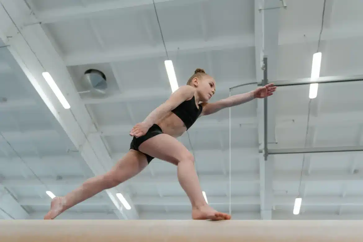 Enfant en tenue de sport s'entraînant dans une salle de gym, illustrant le lien entre activité physique et développement