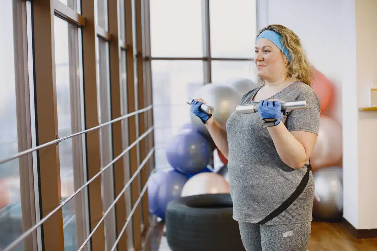 Femme effectuant différents exercices d'haltères en salle de sport