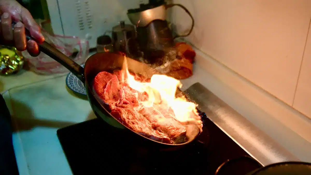 Cuisson à haute température : poêle avec viande dorée et graisse chaude