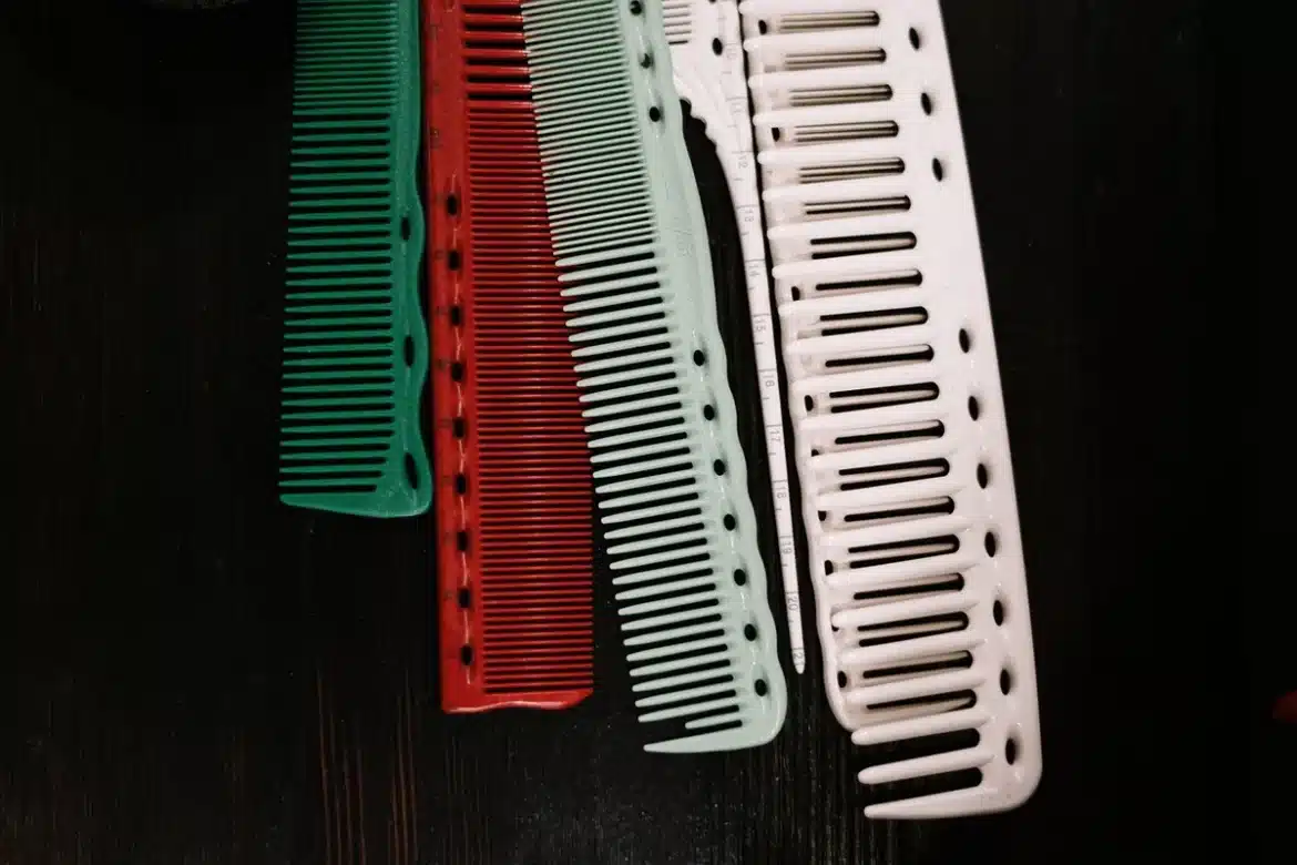 Parent démêlant les cheveux mouillés d'un enfant avec un peigne à dents fines au-dessus d'un lavabo