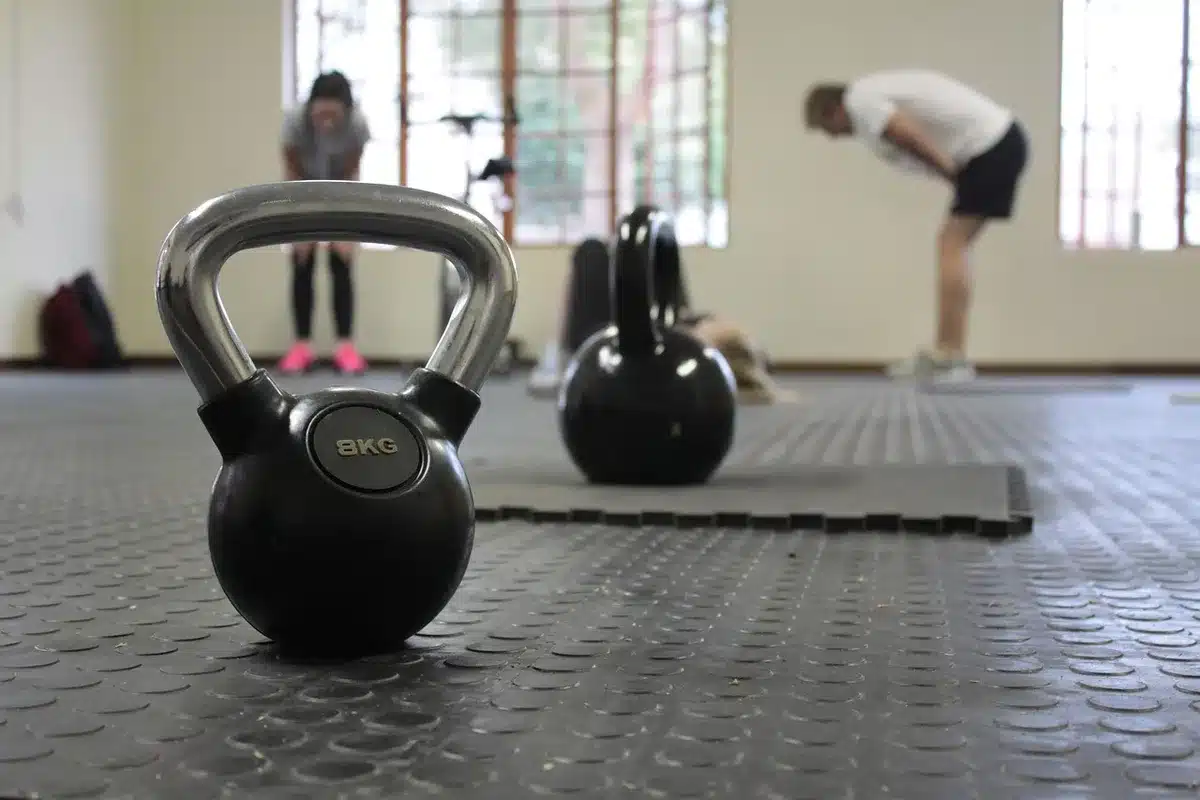 Personne non identifiable effectuant un squat avec kettlebell en salle