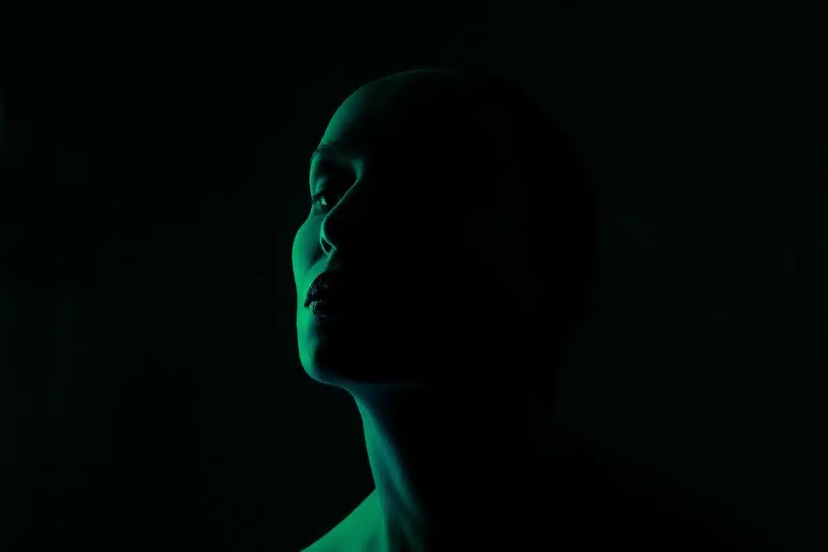 Personne regardant son visage dans un miroir près d'une fenêtre en plein jour
