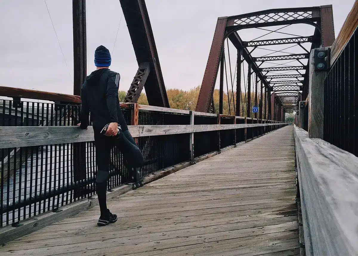 Personne réalisant un pont fessier sur un tapis de yoga dans une pièce lumineuse