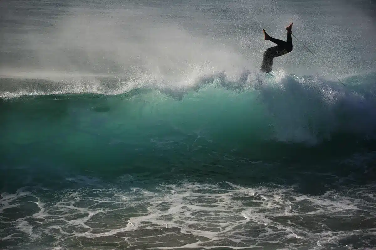 Surfeur près de l'eau portant une cagoule et des bouchons d'oreille