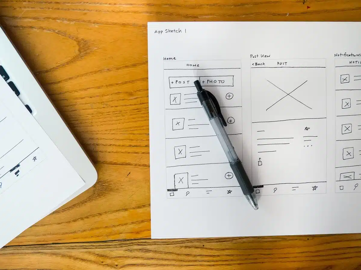 Carnet papier à côté d'un smartphone affichant une application d'entraînement