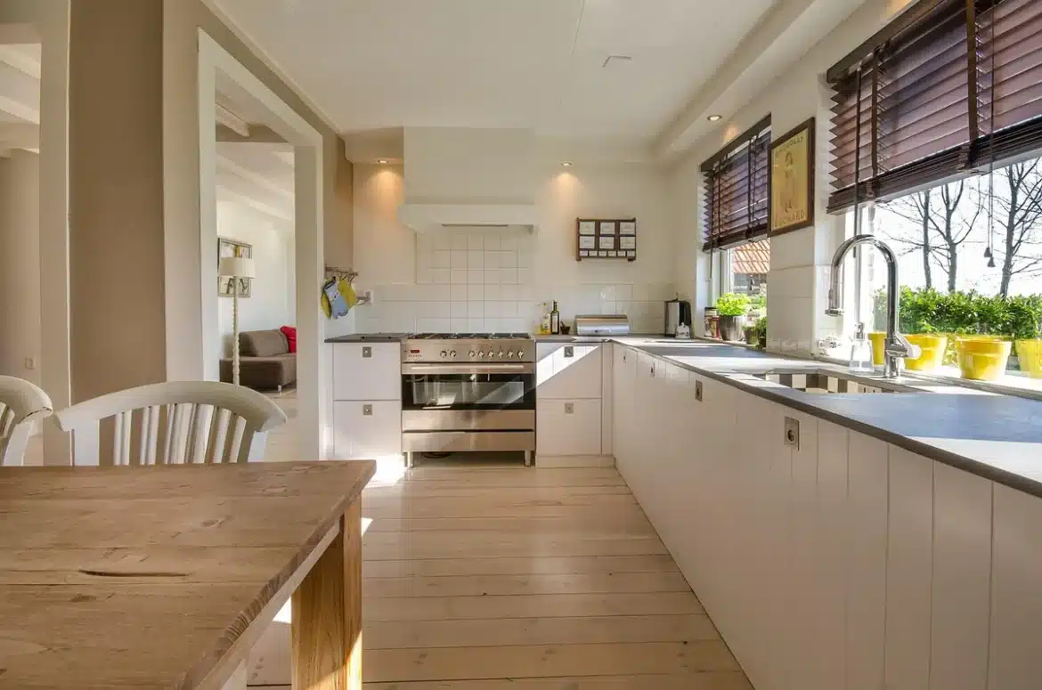 Mains sur une table de cuisine en plein jour avec boîte de compléments floue en arrière-plan
